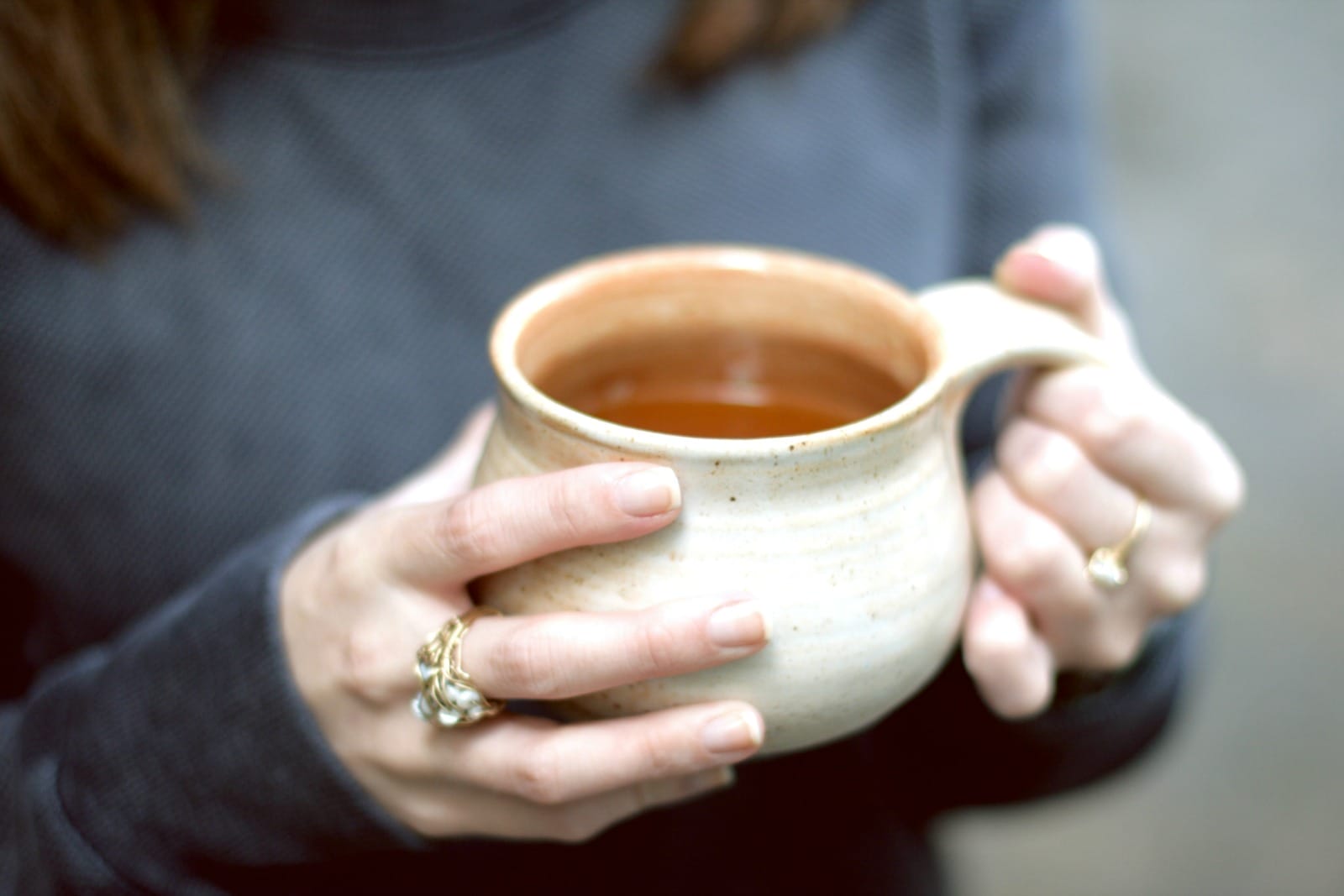 someone holding cider in mug