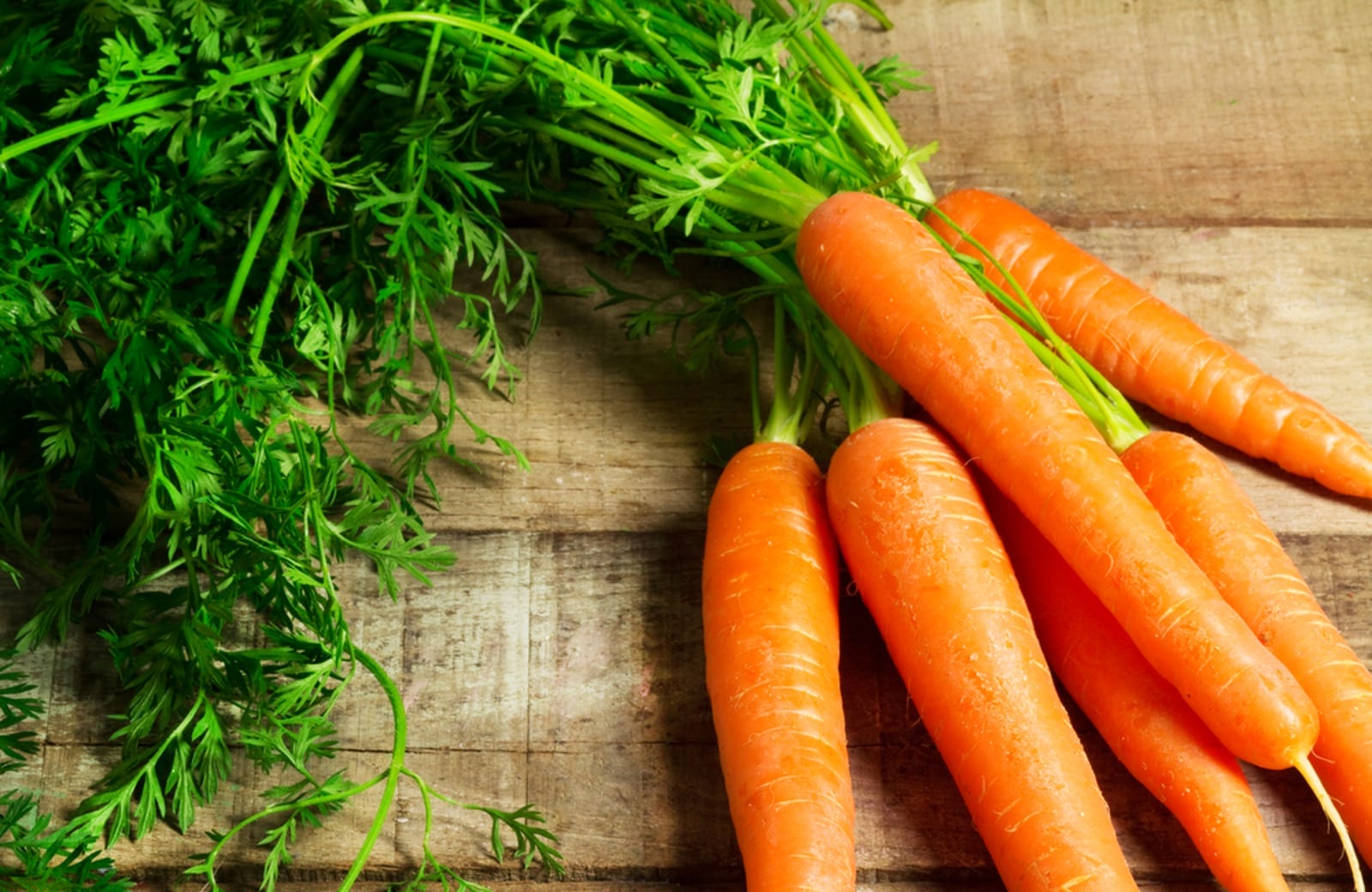 bunch of carrots of chopping board