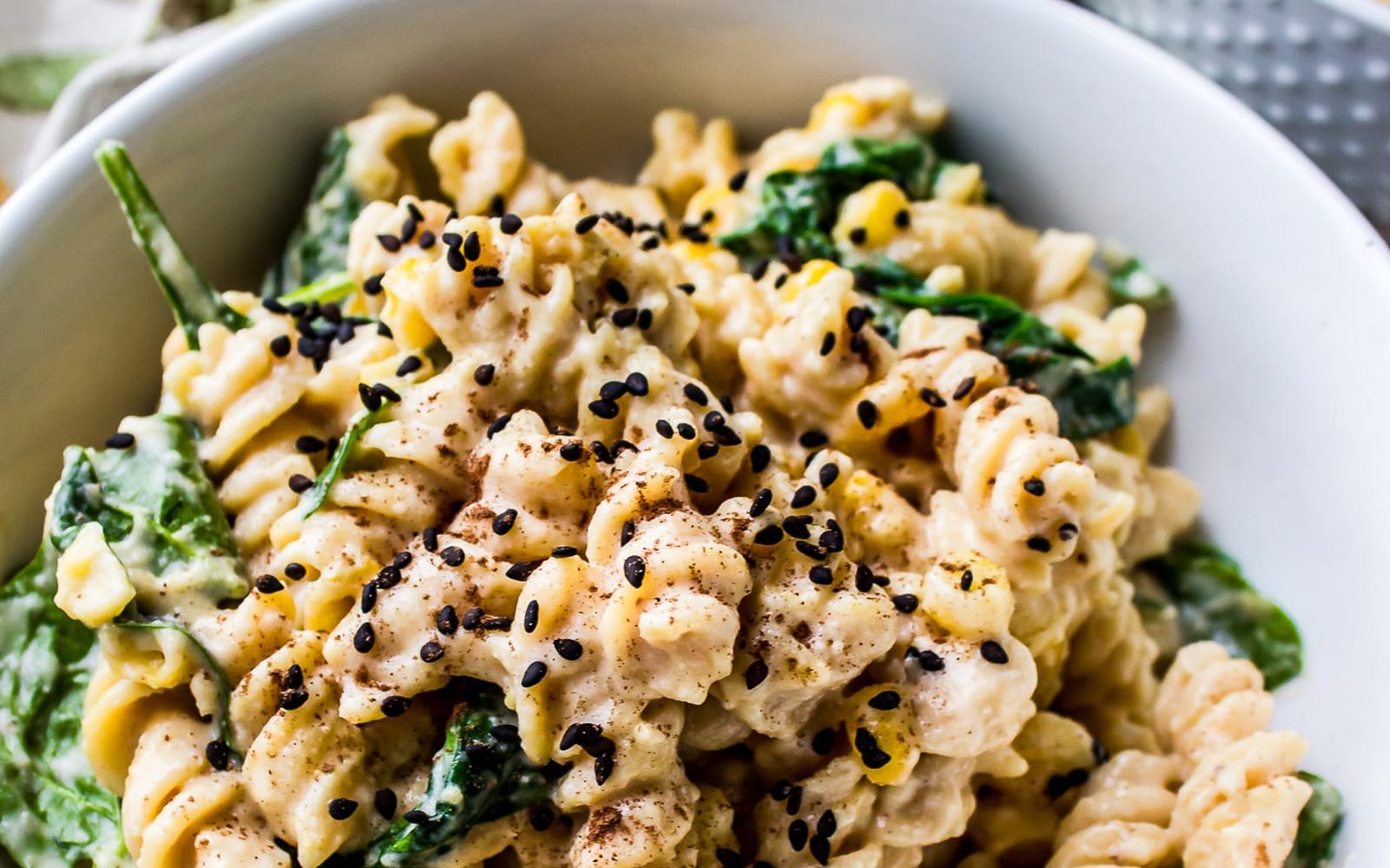 Vegan Gluten-Free Pumpkin Alfredo With Spinach and Corn with sesame seeds