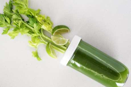 Glass of celery juice with celery plant coming out