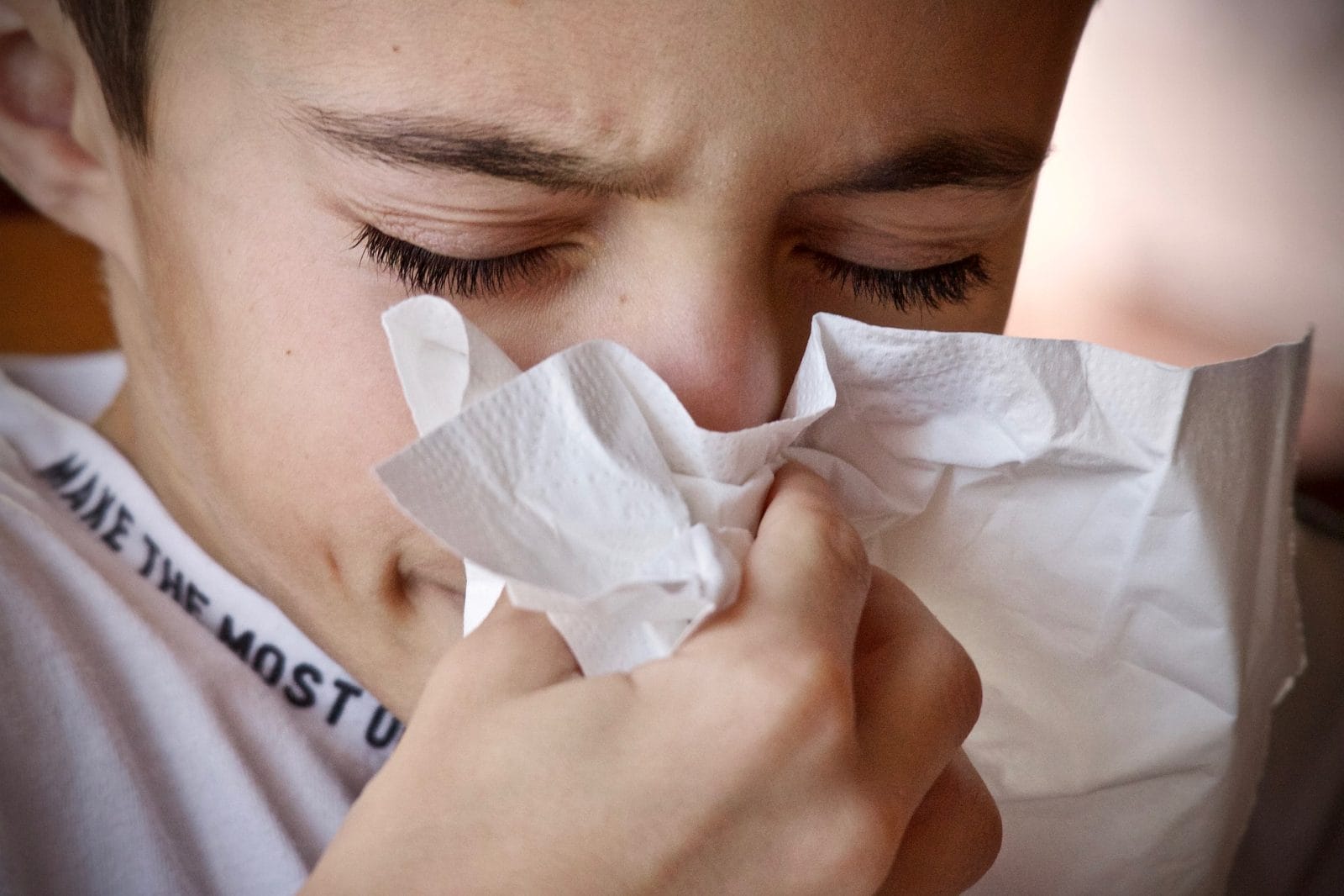 girl blowing nose into tissue