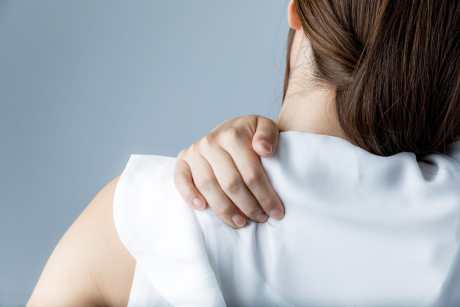 woman with muscle stiffness in shoulders