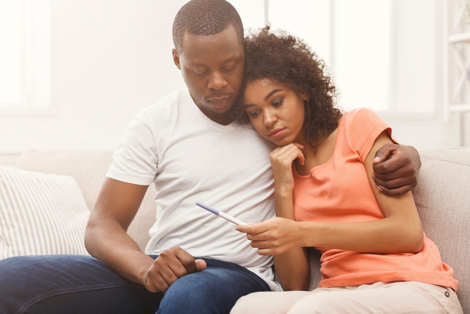 couple looking at a pregnancy test looking disappointed