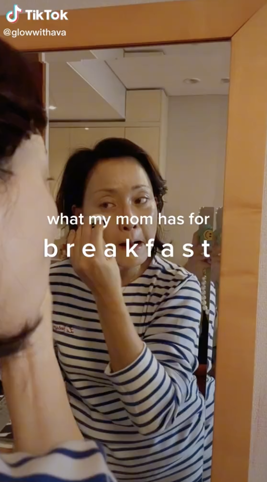 Woman putting on makeup and looking at a mirror