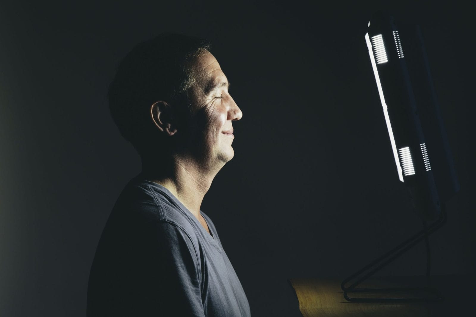 man smiling in front of a light