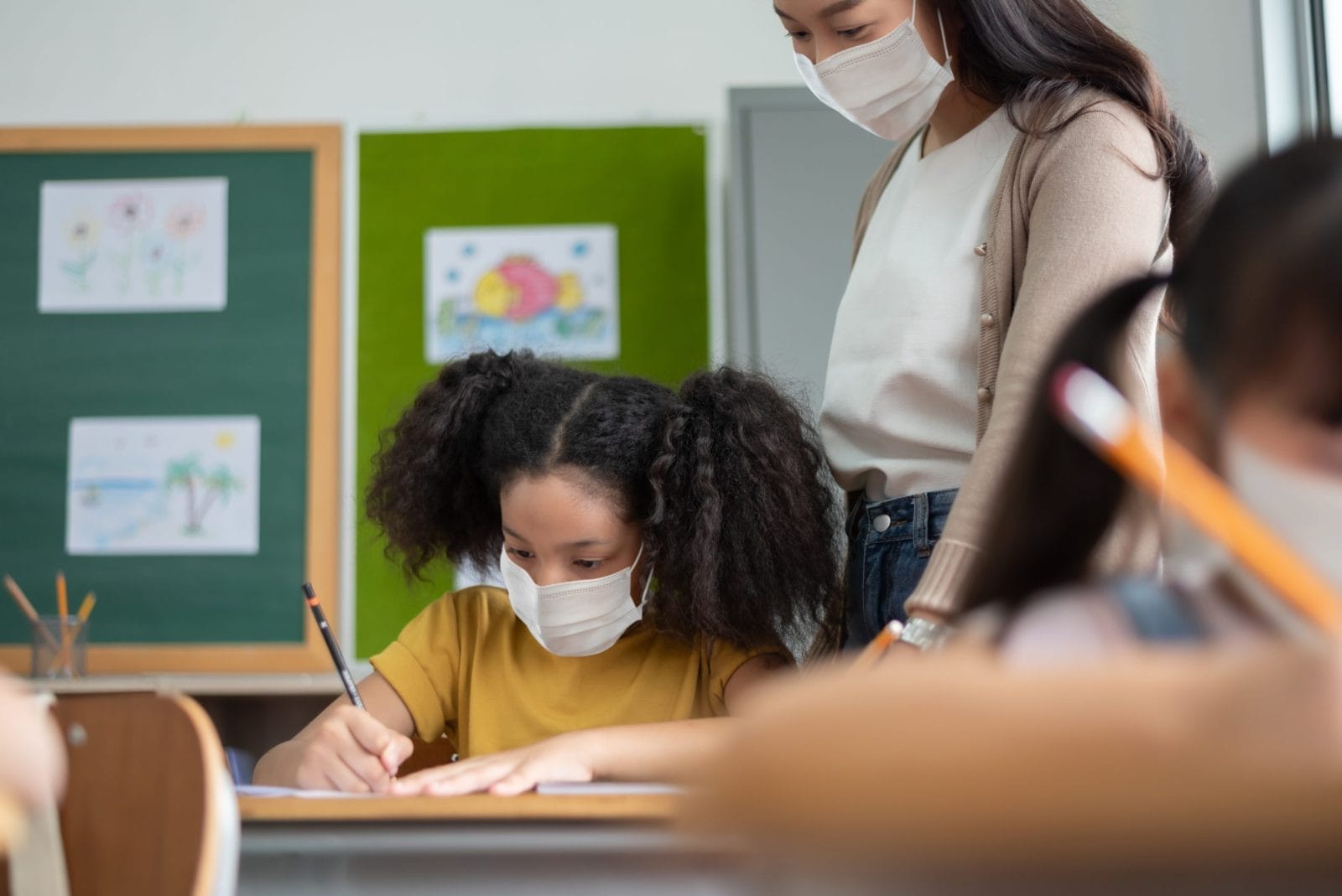 Girl student and teacher with masks on