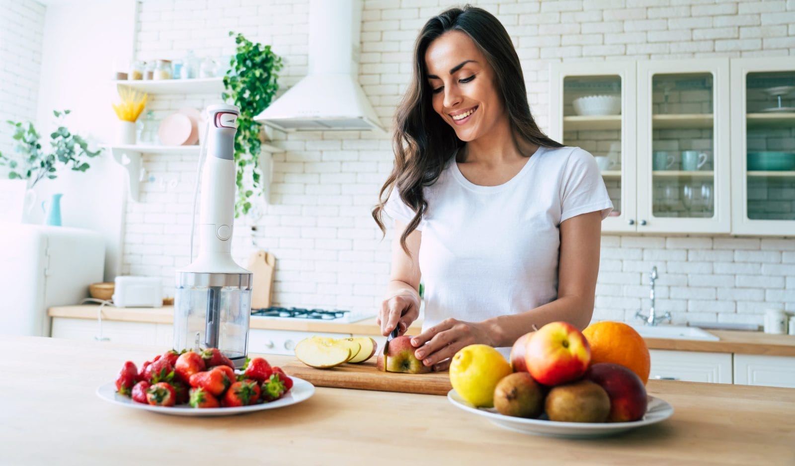 woman cutting up fruit in kitchen