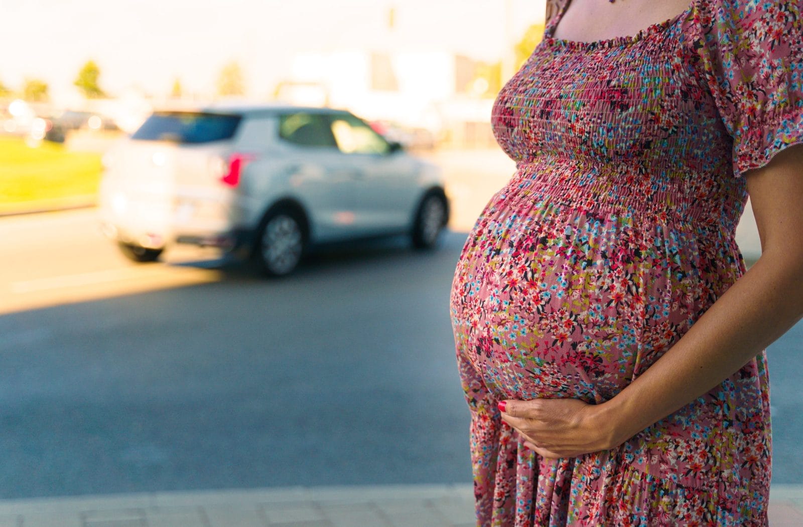 Close-up of a pregnant belly with a city street