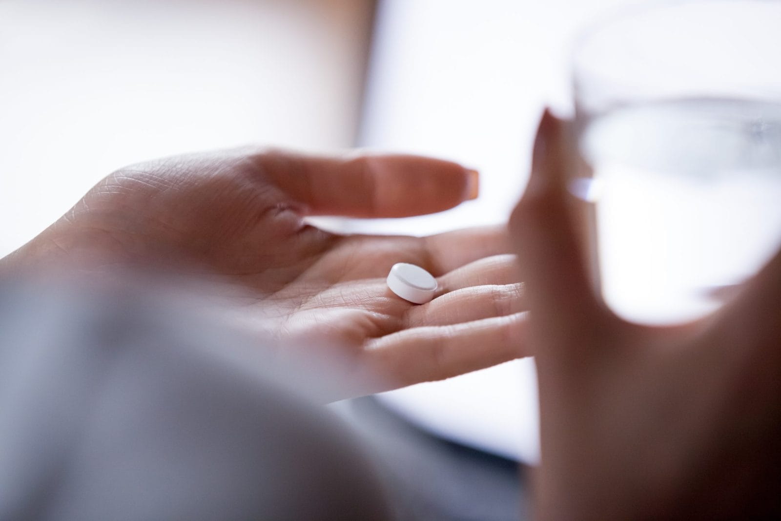 Woman about to take pill with glass of water