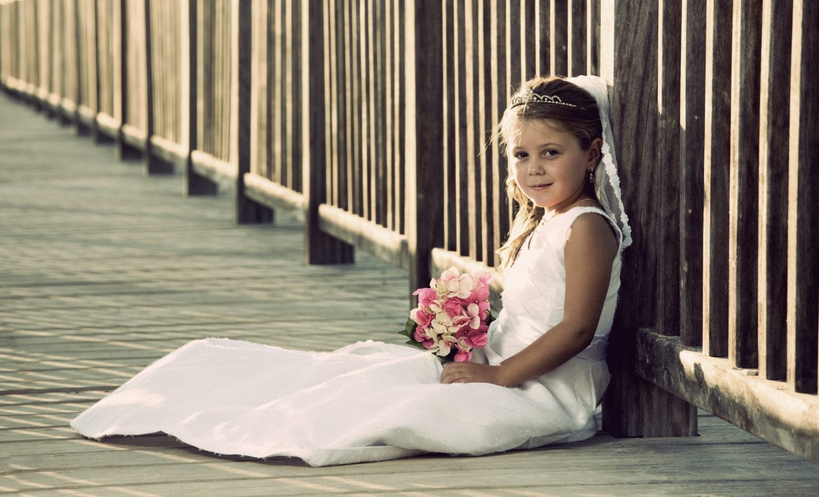 Young girl in wedding dress holding flowers