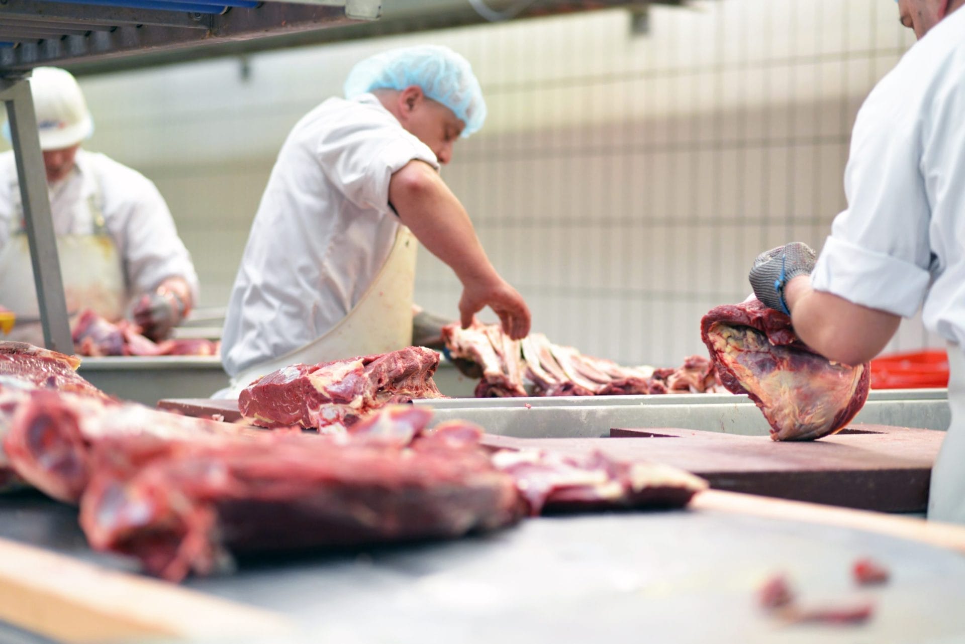 Butchers cutting meat in a slaughterhouse