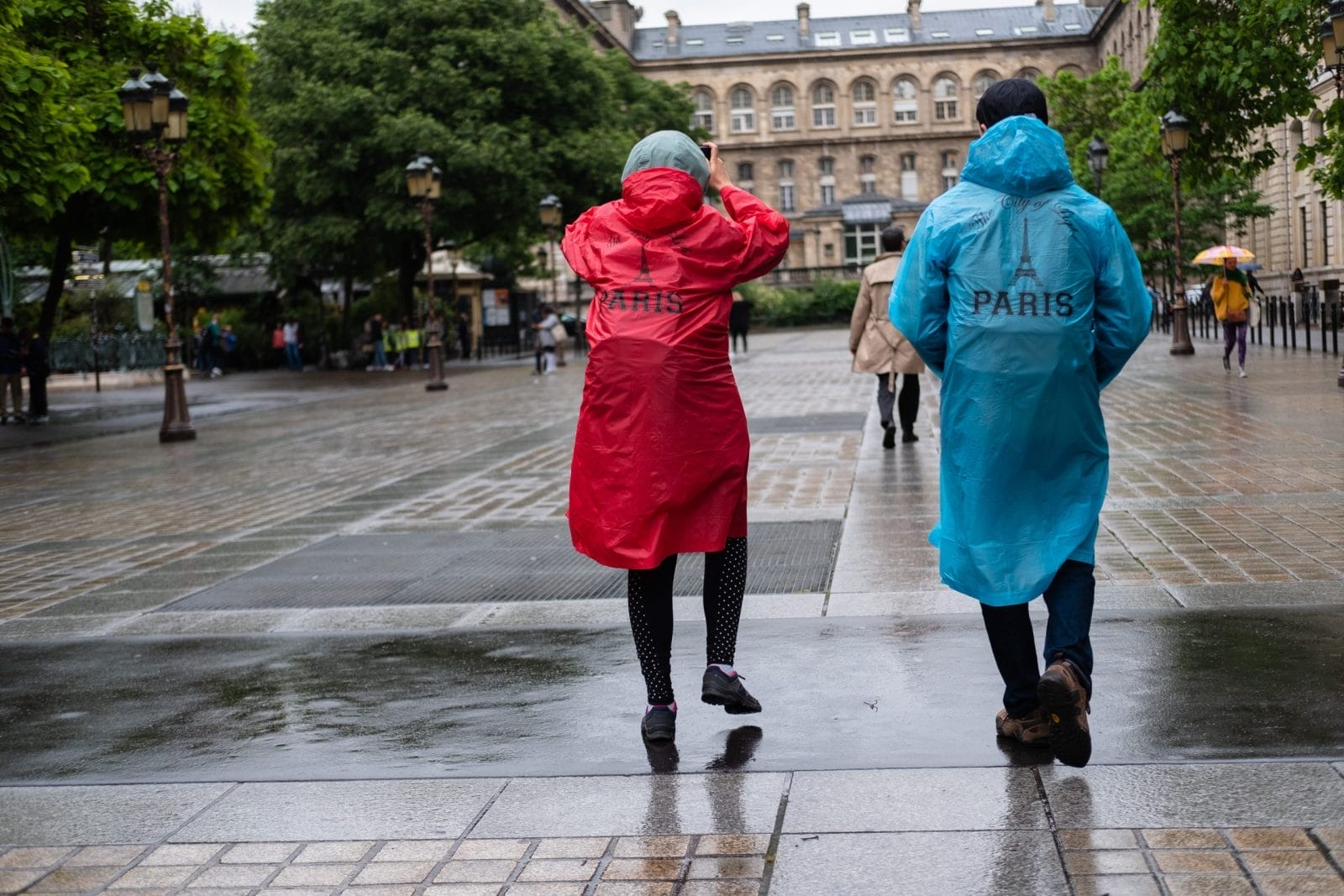 Two tourists taking pictures of Paris France in the rain