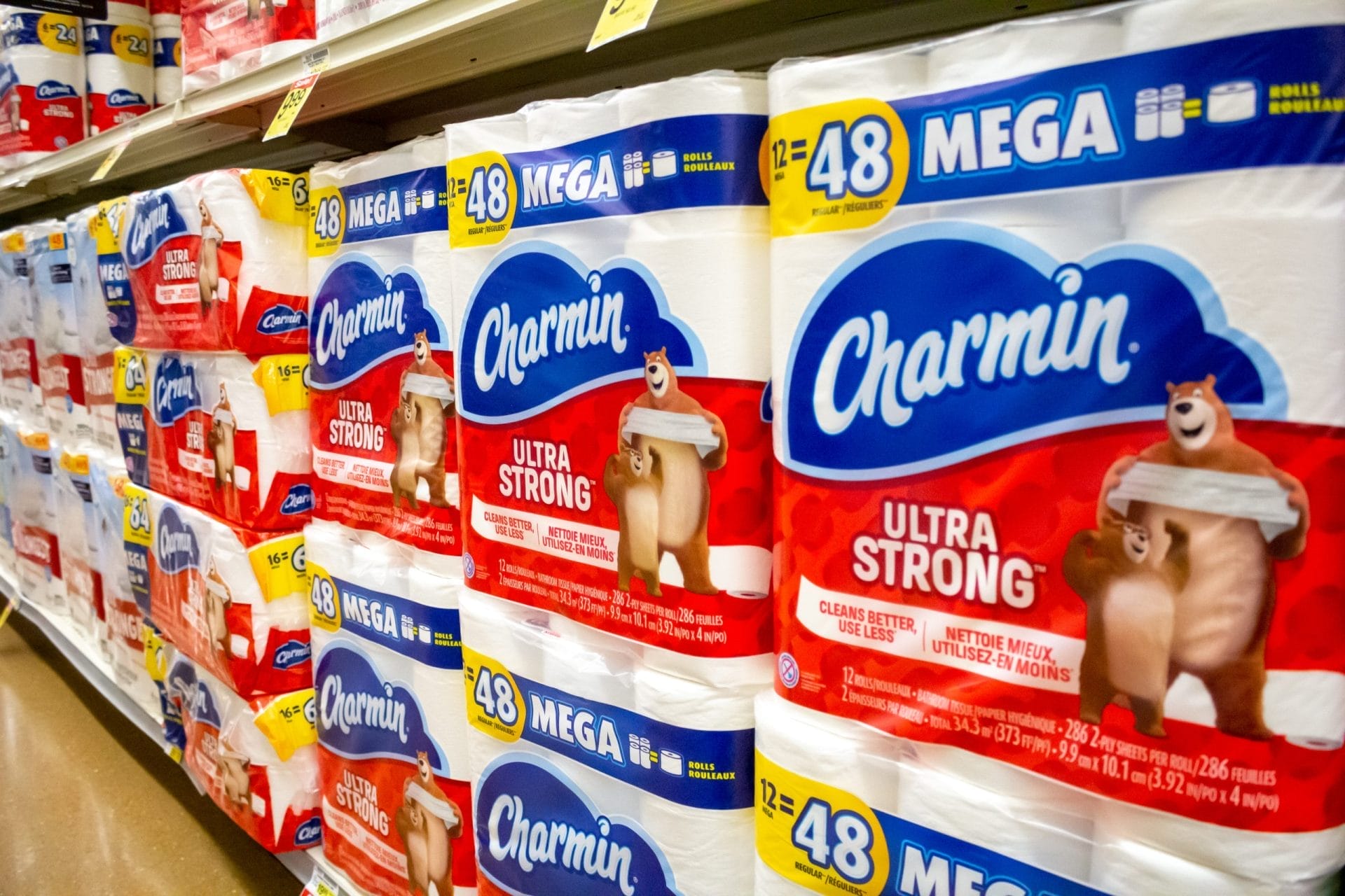 Several packs of Charmin Ultra Strong toilet paper at the grocery store.