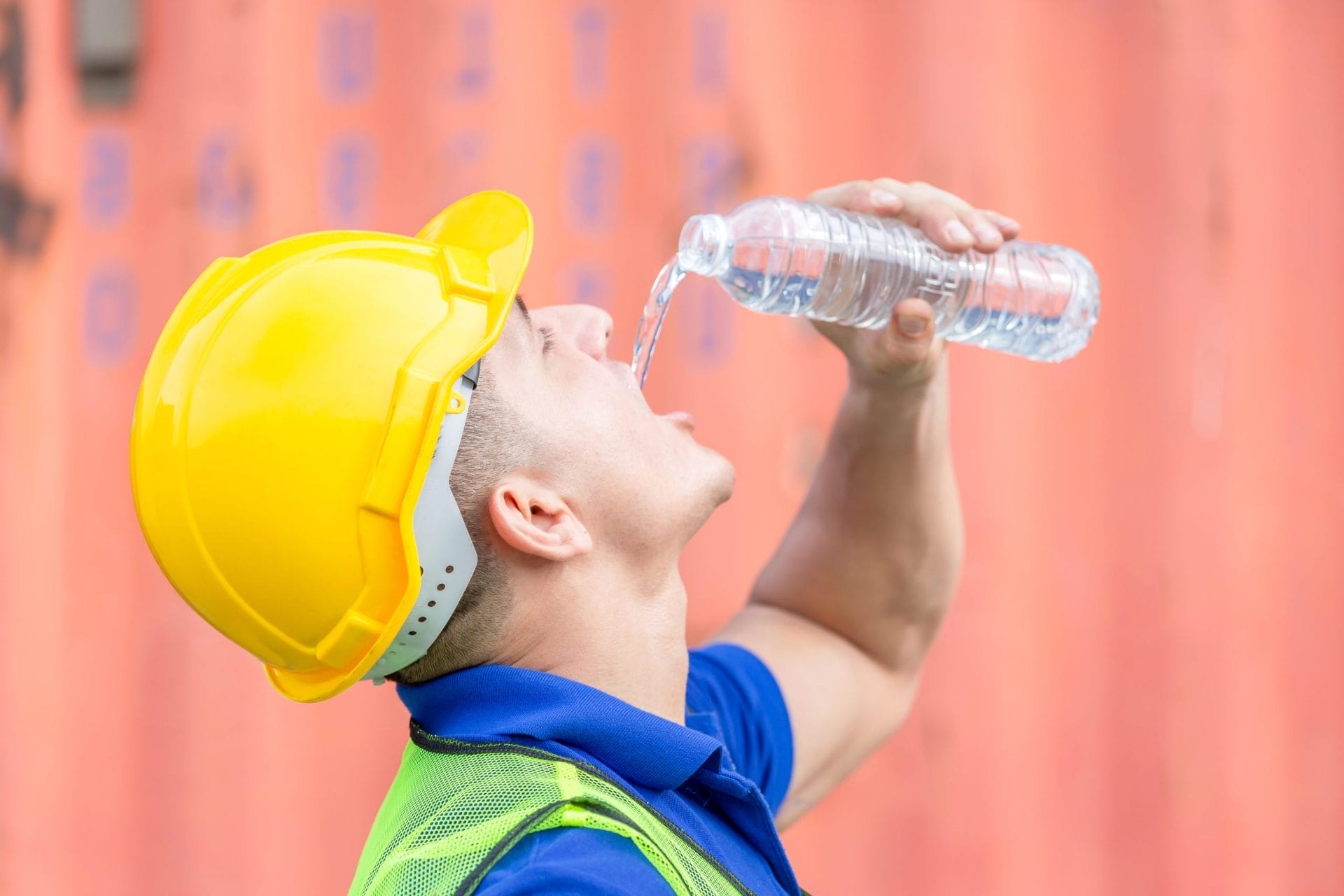 Worker in hard hat drinking water