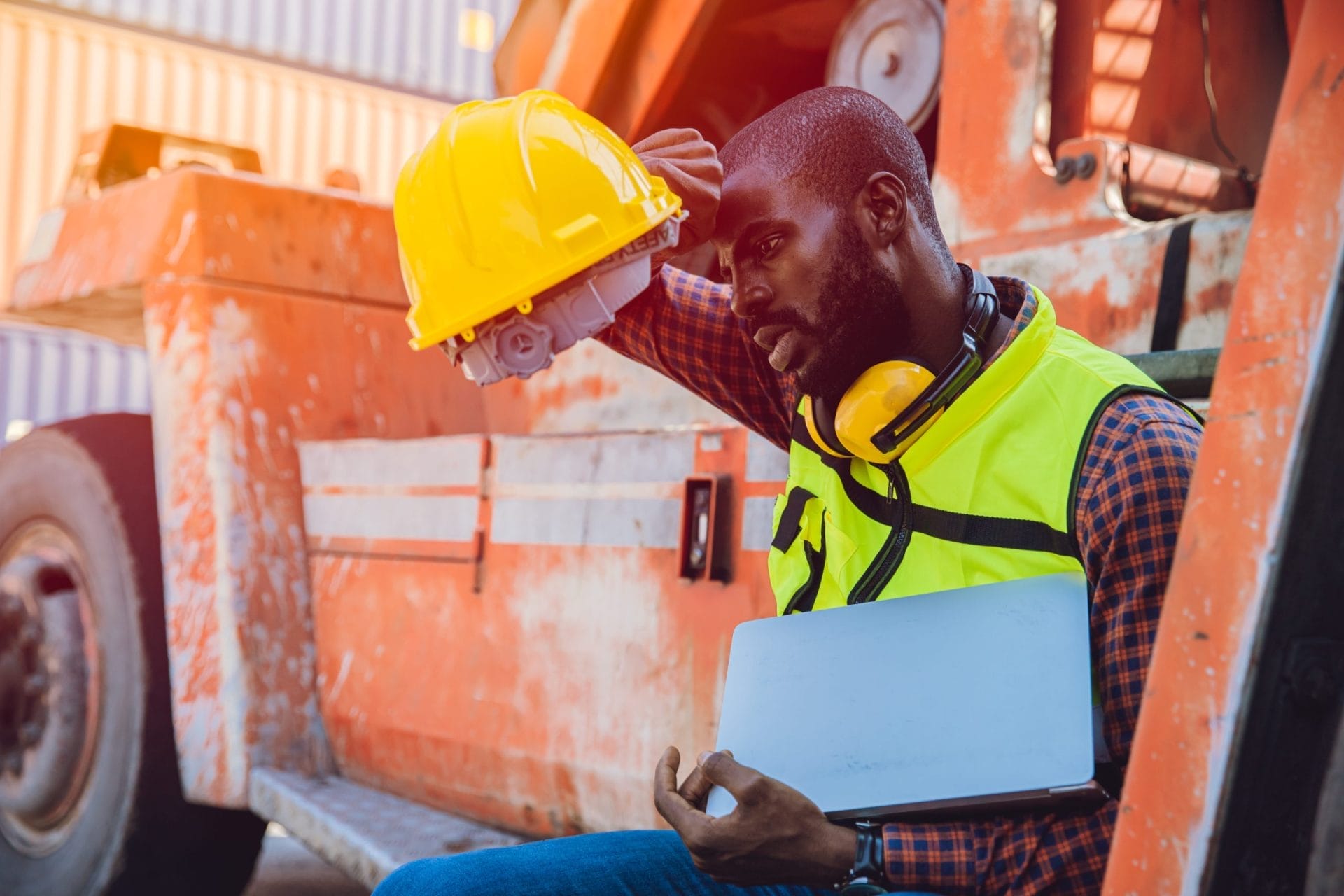 Construction worker wiping sweat off forehead