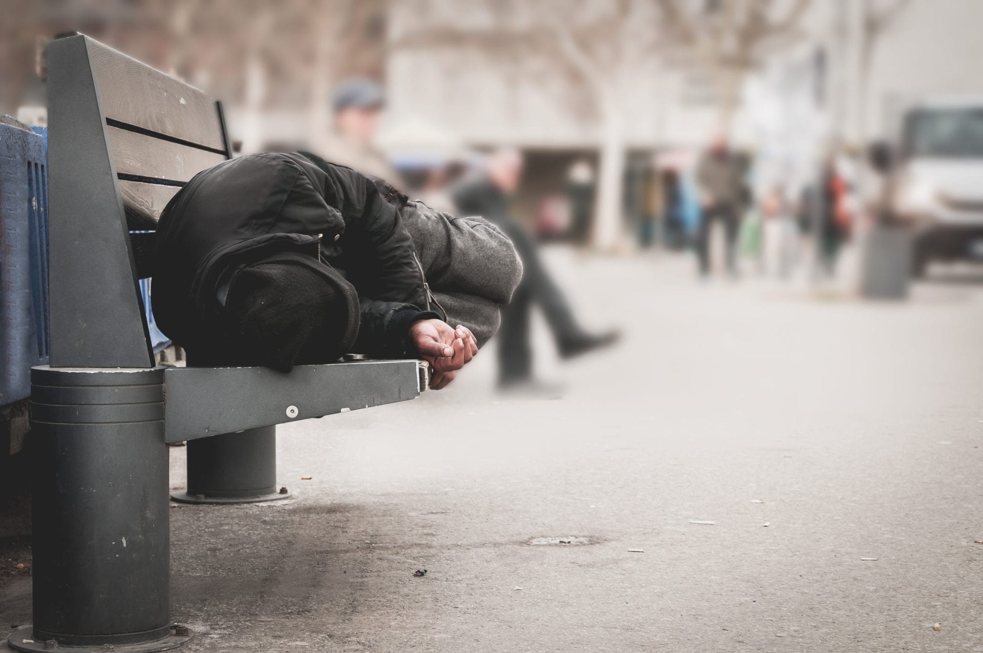 Homeless man sleeping on a bench