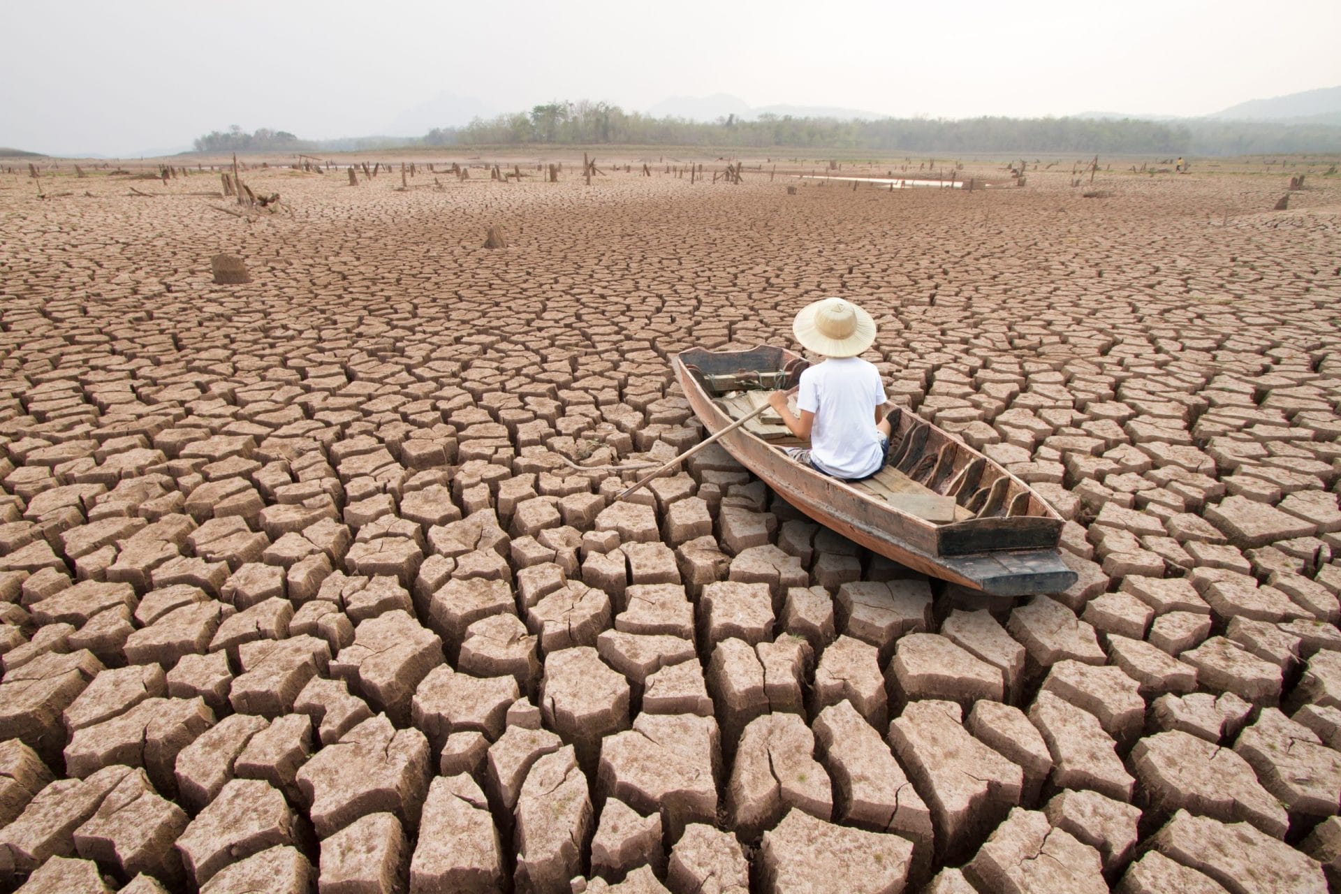 Man in a boat on dry and cracked land