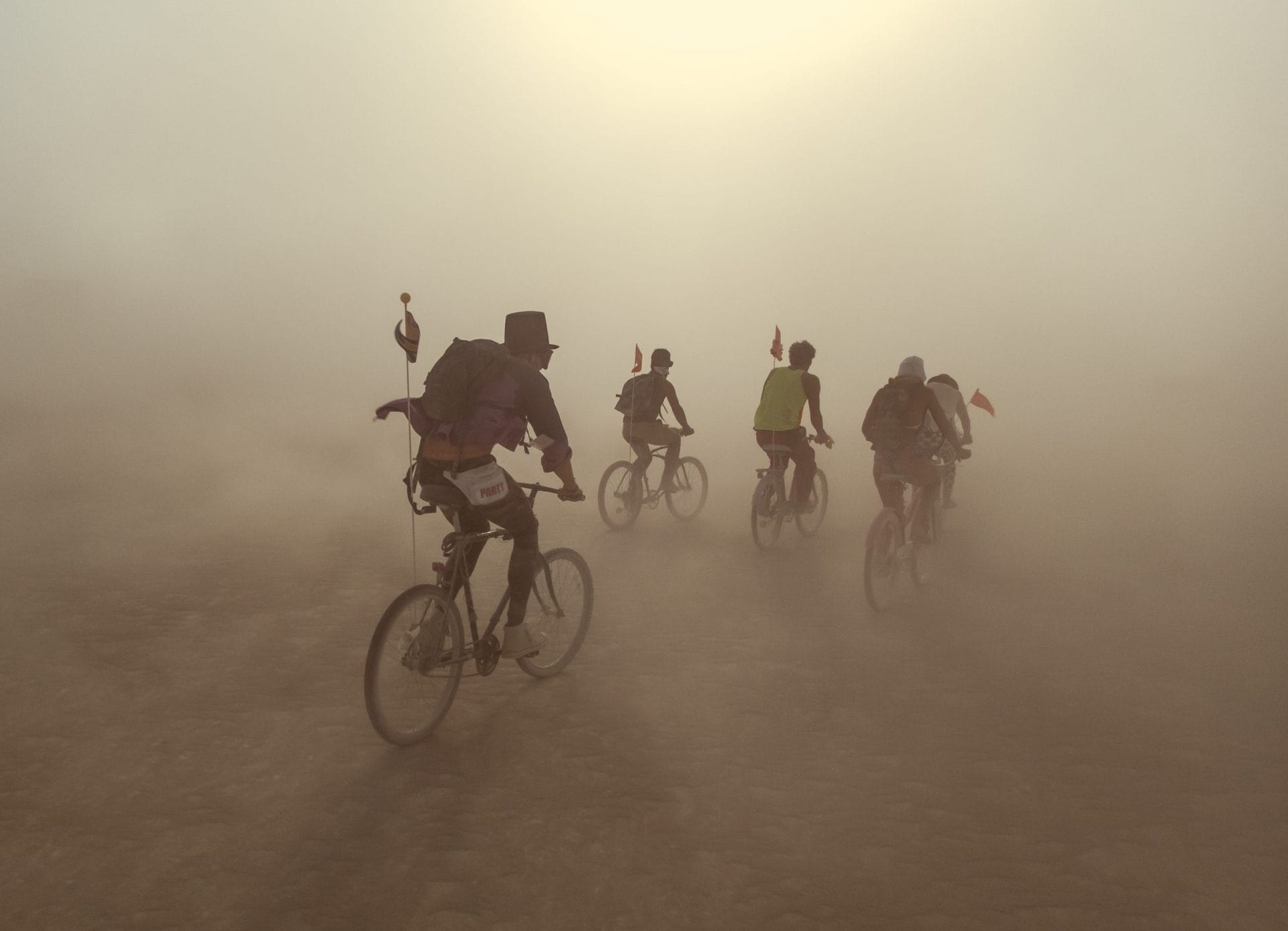 People riding bicycles in a dust storm