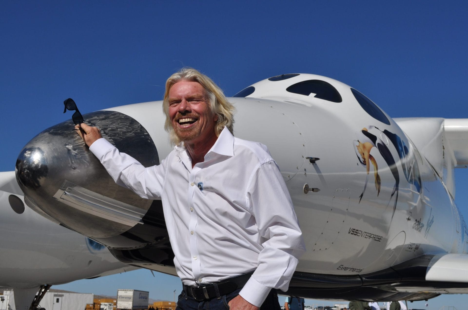 Richard Branson standing next to plane