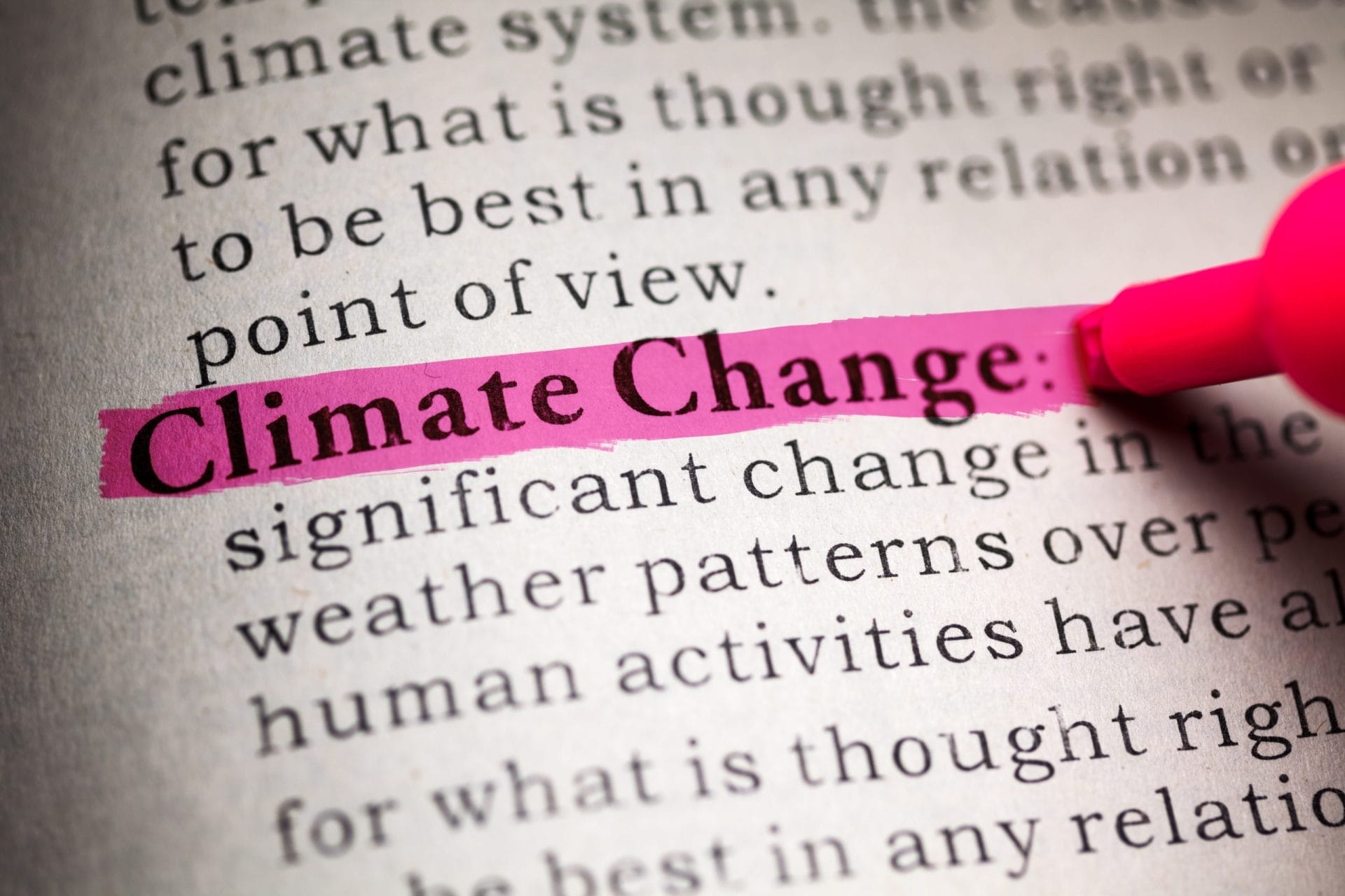 Person highlighting the word climate change in book