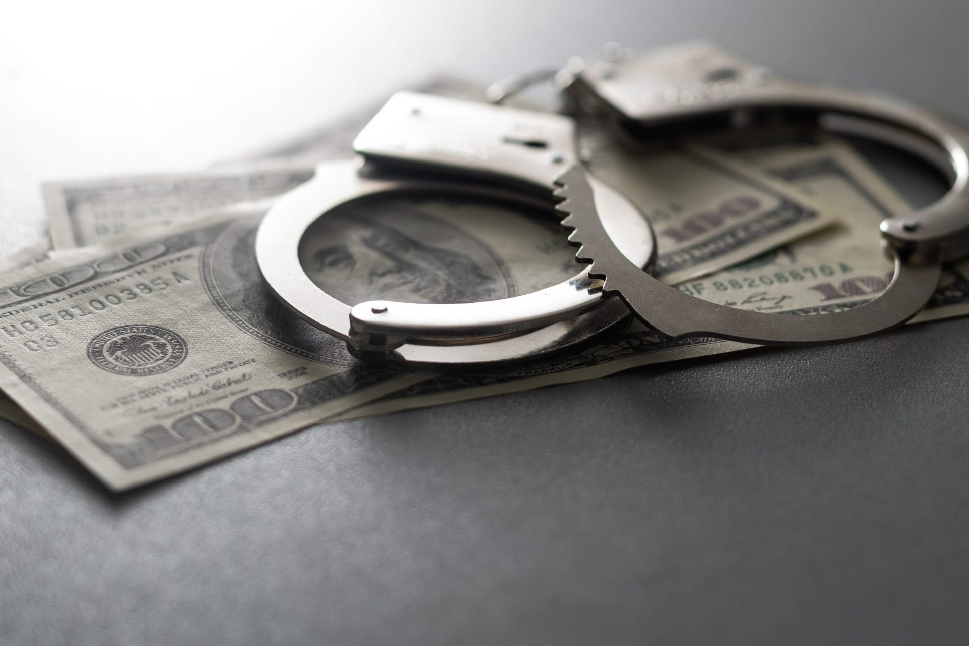 Handcuffs on top of $100 bills