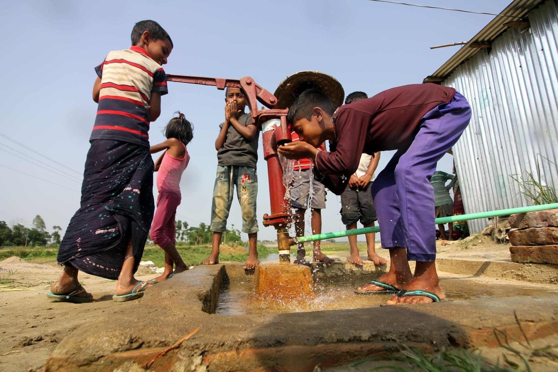 Children drinking water from well in Bangladesh