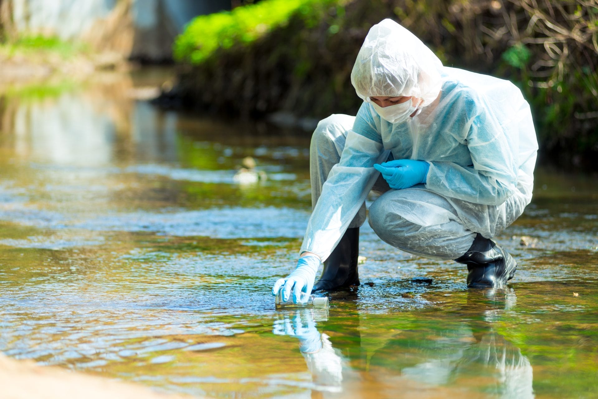 Scientist takes water analysis from polluted river