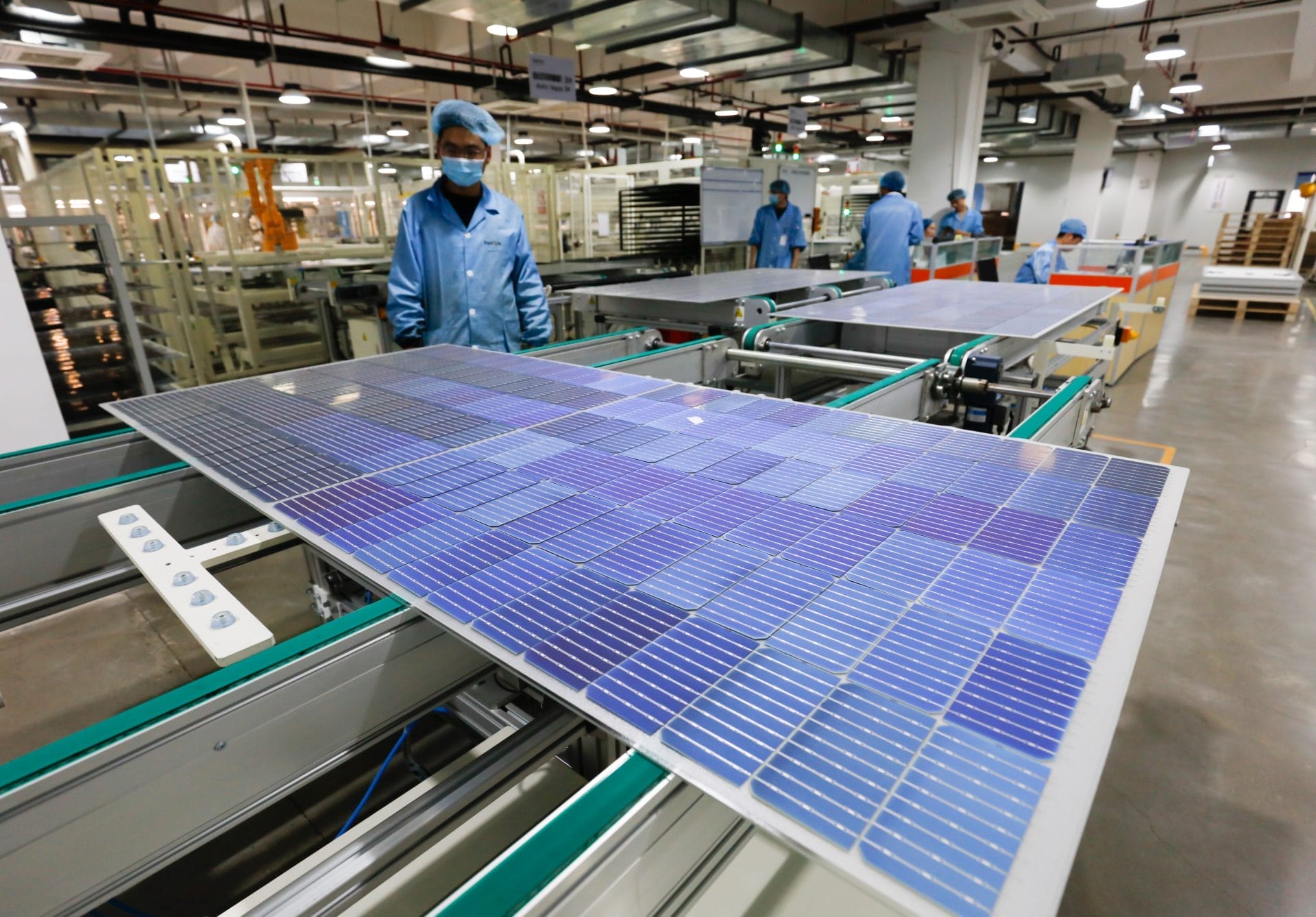 Worker and solar panel in a factory