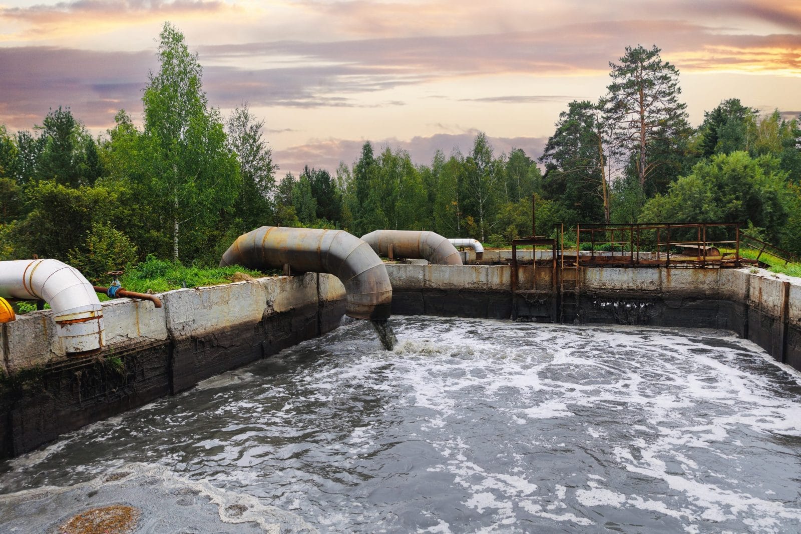 Pipes with waste water of industry is discharged into tank of treatment plant.