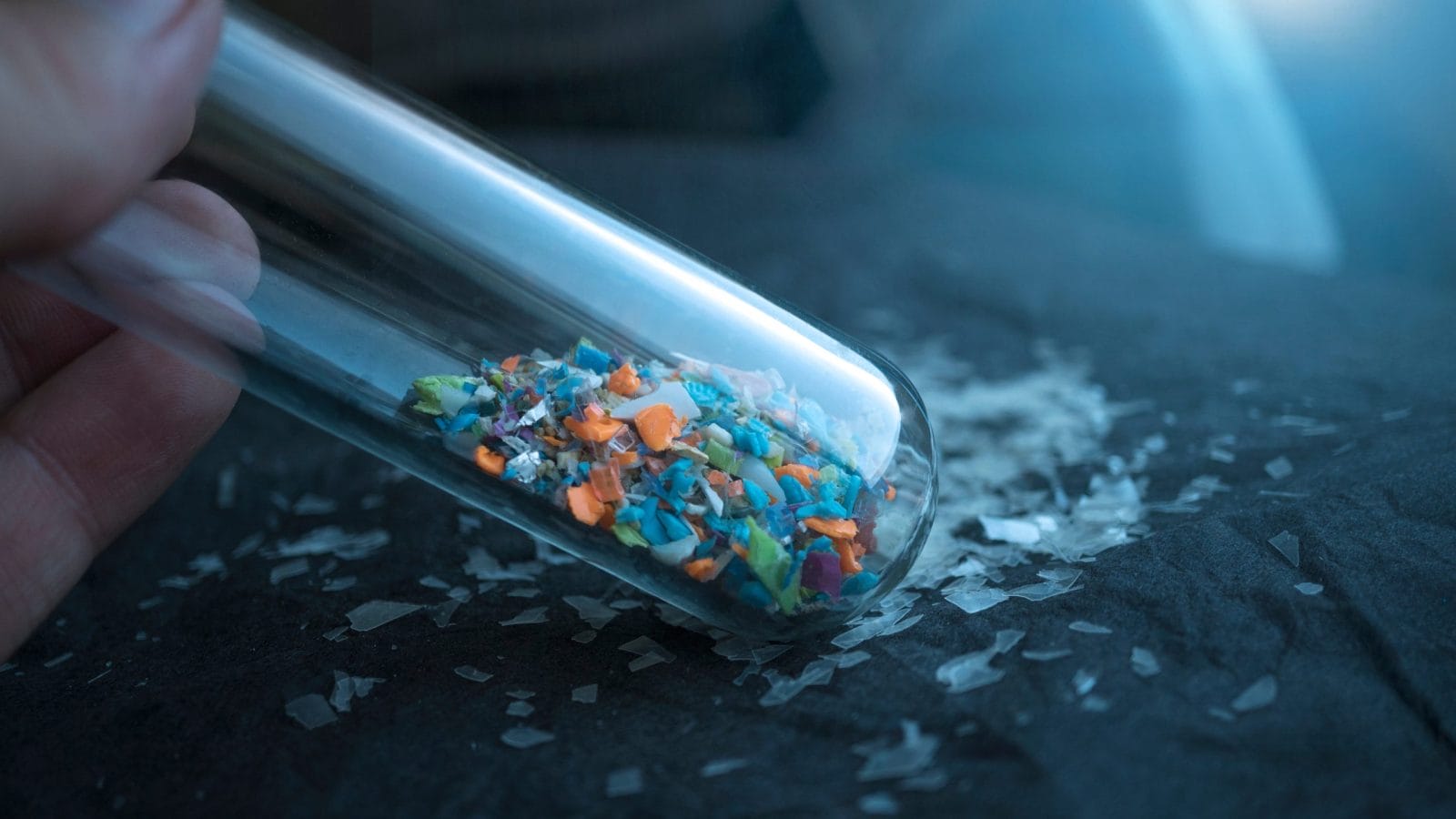 Microplastics inside a glass lab test tube. Concept of plastic pollution and industrial waste management.