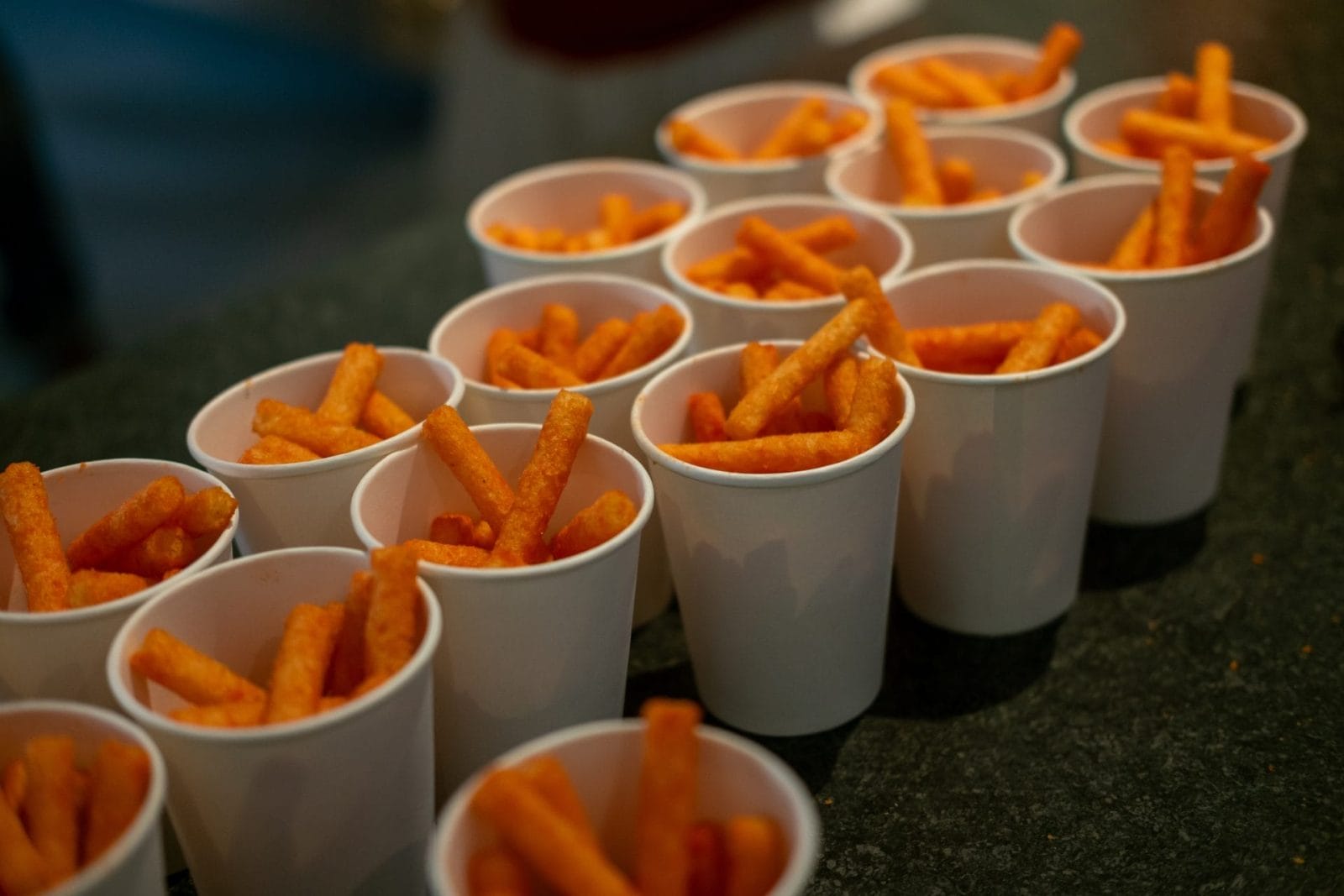 snacks made from corn and flour with artificial flavors, popular among children, served in paper cups